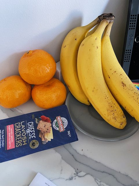 Fruit, bananas, mandarines and snacks, cheese and biscuits.
