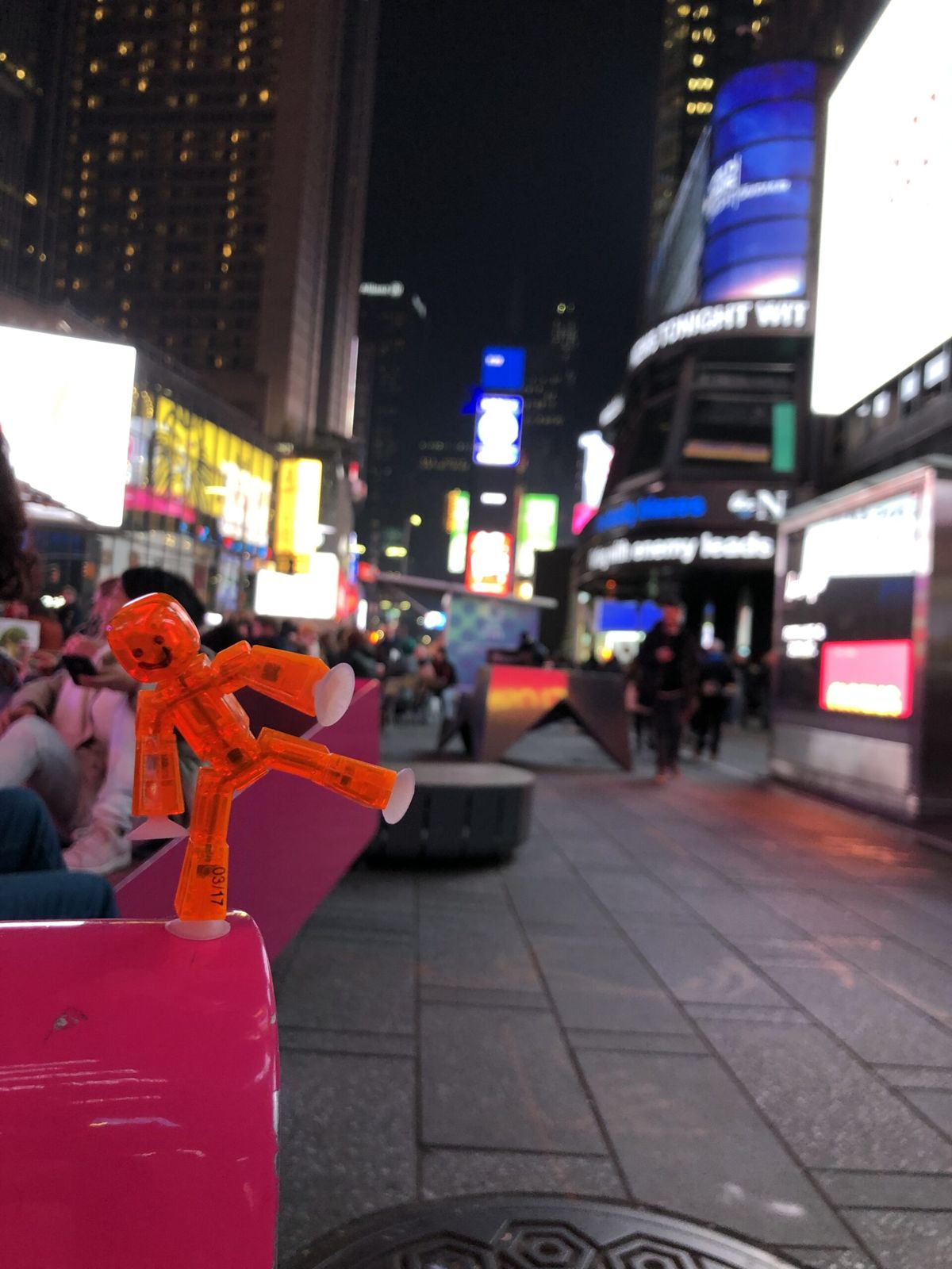 A shot of Broadway and times square at night, blurred out deliberately as a children's toy, Patrick (a stop motion character) sits on a pole.